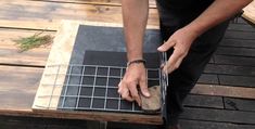 a man is working on some kind of table with wood planks and wire around it