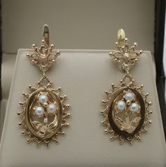 "A pair of vintage Victorian Revival forget me not flower earrings modeled in 14K gold with pearl accents.  We've always adored the symbolism of these flowers - a promise of love and remembrance.  The back of the earrings are stamped \"14K\" for gold purity. Metal: 14K Yellow Gold  Weight: 9.4 grams Measurements: 1.5 inches long by 0.8 inches wide Pearl: 4.4 mm diameter Markings: \"14K\" Condition: In very good vintage condition with some minor surface wear consistent with age.   Follow us on In Wedding Flower Earrings In 14k Yellow Gold, Vintage 14k Gold Earrings With Intricate Design, Classic Drop Flower Earrings For Formal Occasions, Elegant 14k Gold Flower Earrings For Formal Occasions, Victorian Hallmarked Pearl Earrings As Gift, Victorian 14k Gold Jewelry With Matching Earrings, Classic Flower-shaped Pearl Earrings For Formal Occasions, Vintage 14k Gold Wedding Earrings, Elegant 14k Gold Flower Earrings For Anniversary