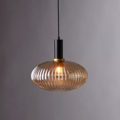 a light that is hanging from the ceiling with a black cord on it and a clear glass shade