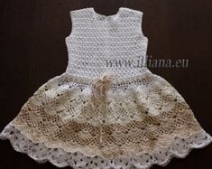 a dress made out of crochet and lace with a bow on the waist