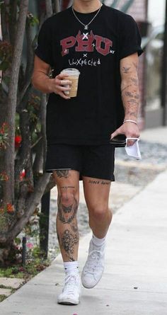 a man with tattoos walking down the street