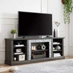 a flat screen tv sitting on top of a wooden entertainment center in a living room