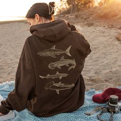 🦈 Sharks Hoodie Sweatshirt for Men and Women | Available in Plus Sizes 🌞 I am the ORIGINAL designer of this shark hoodie! Don't fall for the copycats who steal from other people's livelihoods. ‼️ 🌊 FEATURES: * 50% cotton, 50% polyester (Made from specially spun fibers that make for a very strong, smooth fabric. Polyester fibers are extremely resilient, resistant to most chemicals, stretching, and shrinking.) * Medium-heavy fabric (8.0 oz/yd² (271 g/m * Kangaroo pouch pocket: spacious; keep yo Shark Sweatshirt, Shark Hoodie, Shark Lover, Sports Sweatshirts, Great White, Graphic Shirt, Hooded Sweater, Hoodie Jacket, Graphic Shirts