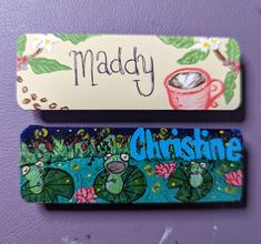 two magnets that are sitting on top of a purple wall, one has a cup of coffee and the other has a name tag