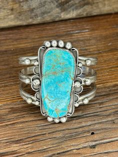 This Eye-Catching Turquoise Sterling Silver Cuff Bracelet is made by Navajo Silversmith Artist MM with highly sought after Kingman Turquoise.  This huge free form shaped stone has exquisite vibrant coloring with stunning copper vein accents and is set into a serrated sterling silver bezel and surrounded by curved designs adorned with 'raindrop' accents.  This show-stopper bracelet would make the perfect gift for yourself, a friend or spouse for any special occasion! ★Specifics★ Metal: Sterling S Western Turquoise Bangle Cuff Bracelet, Western Style Turquoise Bangle Cuff Bracelet, Handmade Turquoise Western Cuff Bracelet, Western Turquoise Bracelet With Patina, Turquoise Concho Bohemian Cuff Bracelet, Bohemian Turquoise Cuff Bracelet With Concho, Bohemian Turquoise Concho Cuff Bracelet, Turquoise Bohemian Cuff Bracelet With Concho, Cute Nike Shoes