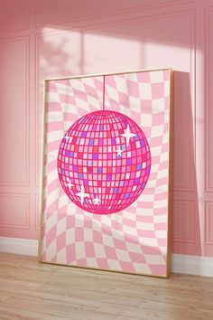 a pink and white checkered wall with a disco ball hanging from it's center