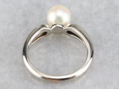 This gorgeous vintage piece is crafted of sleek white gold that features a perfect polish. Utterly simple, this vintage piece features a single, modestly sized pearl framed by rounded tapered shoulders. Metal: 14K White Gold Gem: Pearl Gem Measurements: 7 mm, Round Ring Size: 4.50 Marks: "14K" Stamped on the inside band Classic White Pearl Ring With Drop Detail, Classic Pearl White Ring For Promise, Classic Round Pearl Ring With Pearl Drop, Classic Pearl Ring With Pearl Drop, Classic Pearl Solitaire Rings, Timeless Pearl Ring With Polished Finish For Formal Occasions, Classic Solitaire Pearl Rings, Classic White Pearl Ring With Polished Finish, Classic Pearl Drop Ring