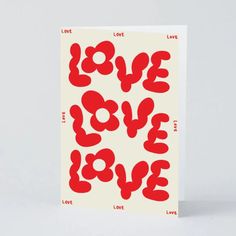 a card with the words love in red and white, on top of a white background