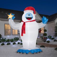 an inflatable snowman with blue feet and red hat standing outside at night