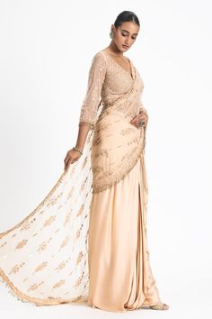 Beige pre-draped saree with net embroidered pallu. Paired with tonal dori, bead, crystal embroidered blouse.
Components: 2
Pattern: Embroidery
Type Of Work: Dori, bead, crystal
Neckline: V neck
Sleeve Type: Three quarter
Fabric: Satin, Net
Color: Beige
Other Details: 
Tassel embroidered sleeve hem
Back tassel tie-up
Occasion: Reception - Aza Fashions Satin Embroidery, Draped Saree, Desi Wedding Dresses, Drape Saree, Desi Wedding, Pattern Embroidery, Blouse For Women, Blouse Online, Saree With Blouse