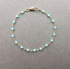 Chalcedony Bracelet This dainty circlet features wire-wrapped aqua chalcedony beads. These stones absolute glow! Fastens with 14K gold filled lobster clasp and components. Boho, graceful, and utterly charming. Aqua chalcedony - faceted rondelles, approximately 3mm Stones are wrapped in gold-plated brass wire Bracelet pictured measures 7 inches in length Please make your length selection from drop down menu ALSO AVAILABLE in Anklet sizes 🌼Arrives beautifully wrapped and ready for gift giving. Al Dainty Blue Round Bead Bracelets, Dainty Blue Beaded Chain Bracelet, Dainty Blue Crystal Bracelet For Gift, Dainty Blue Crystal Bracelet Gift, Blue Dainty Crystal Bracelet Gift, Dainty Blue Bracelets With Faceted Beads, Adjustable Blue Chain Bracelet With Round Beads, Adjustable Blue Round Bead Chain Bracelet, Dainty Blue Bracelet With Adjustable Chain