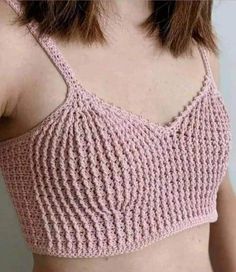 a close up of a woman wearing a pink crop top