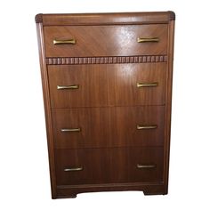 a wooden dresser with four drawers and brass pulls on the bottom drawer, against a white background