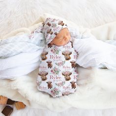 a baby doll laying on top of a white blanket