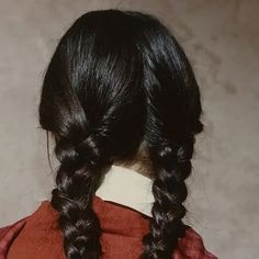 the back of a woman's head with long black hair, wearing a red shirt