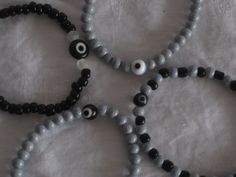 "My 5 year old grandson asked me to make him a bracelet with \"boys\" colors... he picked gray and black seed beads. Then I realized there is not much of boys bracelets out there... so I decided to make a few and see the reaction out there.... Each bracelet has a small evil eye bead, colors of seed beads and evil eye bead can be customized, or choose from the ones pictured here. Black seed beads w/black evil eye Gray seed beads w/black evil eye Gray seed beads w/white evil eye Black and Gray see Handmade Gray Beaded Bracelets With Round Beads, Handmade Gray Beaded Bracelets, Handmade Gray Bracelets With Round Beads, Bracelets For Boys, White Evil Eye, Bracelet For Kids, Boys Bracelets, Ashley Brown, Black Seed