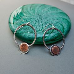 These silver hoop earrings have a bohemian appeal and yet are sophisticated all at the same time. I have formed silver wire into 1" round circles and then textured the wires. I then adorned them with a silver disc with a smaller copper disc in the middle. Each earring is approximately 1 1/8" long. These earrings are light weight, one of a kind and ready to ship. The earrings will be shipped in a linen bag inside a  gift box, ready for gift giving.  *Take a closer look* earring length-1 1/8" earring width-1" disc-4/8",3/8" sterling silver ear wire *Surface Features* Textured Oxidized Artisan Copper Hoop Earrings Nickel Free, Artisan Nickel Free Copper Hoop Earrings, Unique Nickel-free Copper Hoop Earrings, Artisan Silver Round Hoop Earrings, Nickel-free Sterling Silver Open Circle Earrings, Silver Hammered Bohemian Earrings, Bohemian Silver Hammered Earrings, Nickel Free Open Circle Metal Earrings, Nickel-free Metal Earrings With Open Circle Design