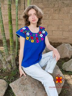 Beautiful blouse made by hand in Chiapas, Mexico creating fashion and art. This is a blue blouse with beautiful colorful flowers and short sleeve. Very comfortable, Goes great with jeans, leggings, skirt, shorts... SIZES This blouse is one size, it can fit small and medium sizes Each piece is unique and handmade with dedication and taking care of every detail achieving the best quality in our products, which is why it makes it beautiful and unique each of the embroidered flowers. 1 piece per ord Traditional Blue Summer Shirt, Traditional Blue Shirt For Summer, Blue Floral Embroidered Short Sleeve T-shirt, Traditional Embroidered Summer T-shirt, Blue Embroidered Short Sleeve Shirt, Blue Floral Embroidery Short Sleeve T-shirt, Handmade Bohemian Blue Tops, Handmade Blue Bohemian Tops, Blue Folk Style Short Sleeve Blouse