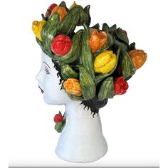 a ceramic head with fruits and vegetables on it's face, as well as an image of a woman's head