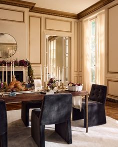 an elegant dining room with candles and flowers on the table