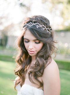 a woman with long hair wearing a white dress and a headband on her head