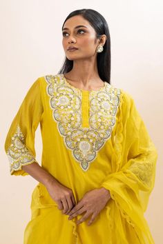 Yellow kurta with floral embroidered yoke and cuffs. Paired with a pant and dupatta.
Components: 3
Pattern: Hand Embroidery
Type Of Work: Floral, Chid, Pearls
Neckline: Round Neck
Sleeve Type: Three Quarter Sleeves
Fabric: Kurta: Chanderi, Pant: Bamber Silk, Dupatta: Organza, Lining: Mul Cotton
Color: Yellow
Other Details: 
Attached inner lining
Scallop trimmed dupatta
Occasion: Sangeet - Aza Fashions Festive Straight Kurta Sets With Embroidered Border, Navratri Georgette Kurta With Embroidered Border, Cutdana Sets With Straight Kurta For Navratri, Navratri Sets With Straight Kurta And Cutdana, Bollywood Style Fitted Palazzo Set With Embroidered Border, Fitted Bollywood Palazzo Set With Embroidered Border, Navratri Sets With Cutdana And Straight Kurta, Traditional Georgette Kurta With Embroidered Border, Chanderi Churidar With Zari Work