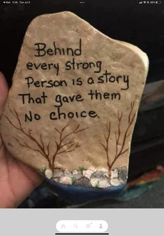 someone is holding up a rock that says, behind every strong person is a story that gave them no choice