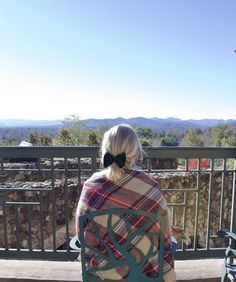 a woman sitting on top of a wooden bench