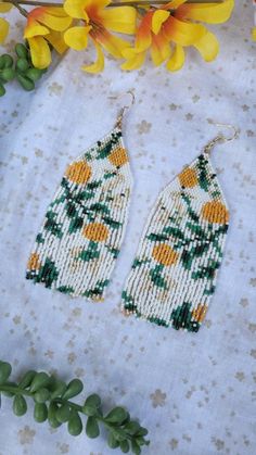 the beaded earrings are next to yellow flowers