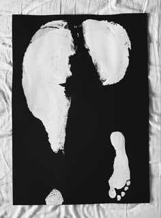 a black and white photo of two footprints on a piece of paper that has been torn off