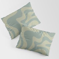 two blue and white pillows sitting on top of each other