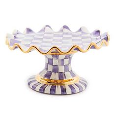 a purple and white checkered cake dish with gold trim