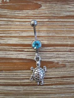 This super cute belly button ring that features a silver turtle charm that hangs from a standard 14 gauge surgical steel barbell with a light blue gem. It measures 3/4 inches long. Thanks for taking a look!   *If you would like this belly button ring in a different color gem or stone, just let me know. I would love to make it for you!* Adjustable Silver Surgical Steel Belly Rings, Silver Dangle Belly Rings Nickel Free, Nickel-free Silver Dangle Belly Rings, Silver Dangle Belly Rings In Stainless Steel, Silver Surgical Steel Belly Rings As Gift, Nickel-free Dangle Belly Rings In Sterling Silver, Silver Hypoallergenic Dangle Belly Rings, Silver Hypoallergenic Surgical Steel Belly Rings, Nickel-free Sterling Silver Dangle Belly Rings