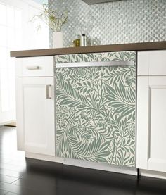 an image of a kitchen setting with white cabinets and green wallpaper on the backsplash