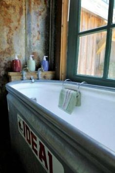 a bath tub sitting next to a window in a bathroom