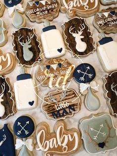 decorated cookies are arranged on a table with words and deer heads in blue, white, and brown