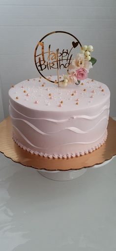 a pink cake sitting on top of a white table