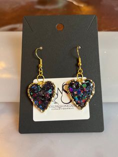 Step into a world of enchantment with our Sparkling Dreams earrings, featuring charming hearts adorned with dazzling glitter in various colors. Each pair is a celebration of individuality, allowing you to express your style with a burst of color and sparkle. Handcrafted with precision, these earrings are versatile enough to complement both casual and formal looks. Key Features: *Handcrafted heart earrings with a variety of glitter colors *Lightweight and comfortable for extended wear *Secure earring backs for a worry-free experience *Unique and eye-catching design for a statement look Materials: These earrings are crafted using high-quality materials, with each heart showcasing a different glitter color. Choose the shade that resonates with your mood or outfit, and let your personality shi Multicolor Jewelry For Valentine's Day Party, Valentine's Day Party Multicolor Jewelry, Multicolor Heart Pendant Jewelry For Parties, Multicolor Dangle Jewelry For Valentine's Day, Sparkling Heart Cut Jewelry For Party, Sparkling Dangle Crystal Earrings Gift, Gift Sparkling Dangle Crystal Earrings, Gold Heart Shaped Crystal Earrings For Party, Sparkling Gold Earrings For Valentine's Day