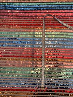 a large multicolored wall hanging made from strips of sequins and fabric