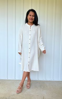 Relax in style with the Aura shirtdress, a unique take on traditional loungewear. Made from breathable double gauze cotton, it's perfect for casual wear out, at home, or even as a beach coverup. The button-down design adds a touch of style and versatility to your wardrobe, ensuring comfort and convenience as you go about your day. Long Cotton Shirt Dress For Vacation, Oversized Button-up Shirt Dress For Beach, Chic Cotton Shirt Dress For Beach, Chic Linen Button-up Dress For The Beach, Chic Cotton Shirt Dress For The Beach, Chic Button-up Linen Dress For The Beach, Relaxed Fit Cotton Button-up Tunic, White Linen Shirt Dress For Beach, White Linen Shirt Dress For The Beach