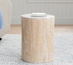 a round wooden table sitting on top of a rug