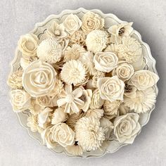 a bowl filled with lots of white flowers on top of a gray countertop next to a knife