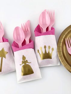 pink and gold plastic utensils in small bags with princess silhouettes on them