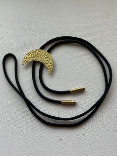 Bright yellow/gold brass crescent moon with floral pattern bolo tie necklace on black nylon cord. Floral Crescent Moon, Bolo Tie Necklace, Tie Necklace, Bolo Ties, Bolo Tie, Gold Brass, Tie Accessories, Black Nylon, Suit And Tie