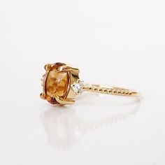 The Oval Citrine Sunrise ring features a natural orange oval citrine center stone. A ring to remind you of the beauty of a sunrise. Handcrafted in your choice of gold vermeil, or 14K solid gold. Also, comes with a diamond and moissanite center stone here. Gold vermeil or 14k solid gold 8x6mm natural oval Citrine Round CZs (what's this?) 1.2mm ring band ** This item is specially made for you. Please allow 1-2 week lead time. ShippingDomestic: Free standard shipping within the U.S.International: F Yellow Gold Citrine Oval Diamond Ring, Orange Oval Topaz Promise Ring, Oval Citrine Diamond Ring In Yellow Gold, Oval Orange Topaz Promise Ring, Oval Orange Topaz Ring For Promise, Oval Citrine Diamond Promise Ring, Oval Orange Topaz Ring With Center Stone, Oval Citrine Diamond Ring, Oval Citrine Diamond Ring With Prong Setting