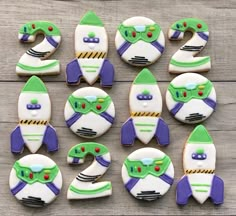 some decorated cookies are sitting on a wooden table and one has a rocket ship in the middle