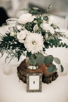 a vase filled with white flowers sitting on top of a table