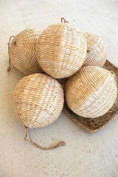 four wicker balls in a basket on the floor