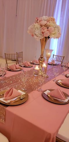 the table is set with pink and gold place settings