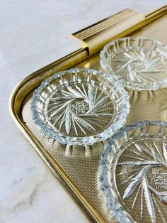 three glass plates sitting on top of a metal tray